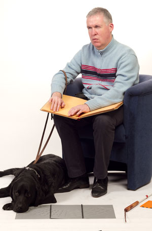 Leendert met hond, stok en braille boek.